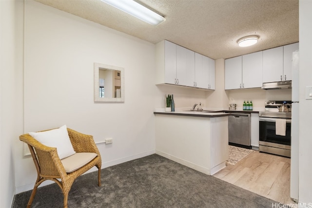 kitchen featuring kitchen peninsula, white cabinets, appliances with stainless steel finishes, a textured ceiling, and wood-type flooring