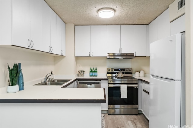 kitchen featuring kitchen peninsula, sink, white cabinetry, appliances with stainless steel finishes, and a textured ceiling