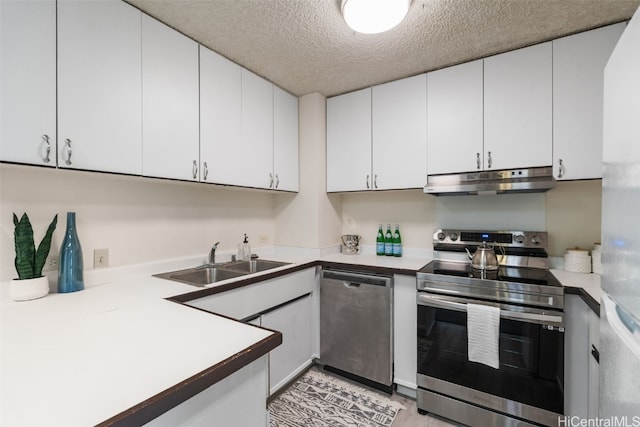 kitchen featuring white cabinets, stainless steel appliances, sink, and a textured ceiling