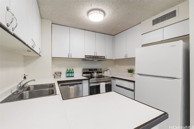 kitchen featuring appliances with stainless steel finishes, white cabinetry, a textured ceiling, and sink