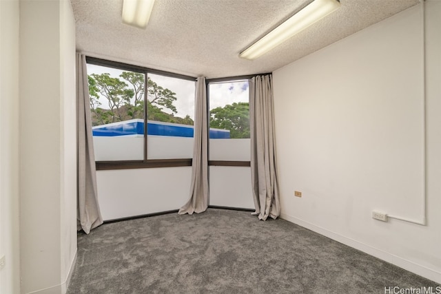 carpeted spare room featuring a textured ceiling