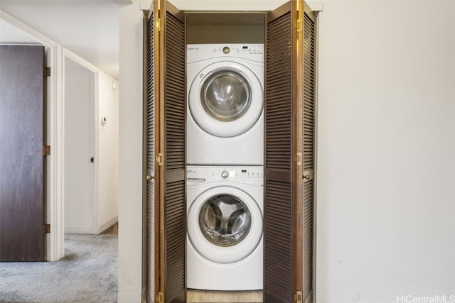 washroom with stacked washer / dryer and light carpet