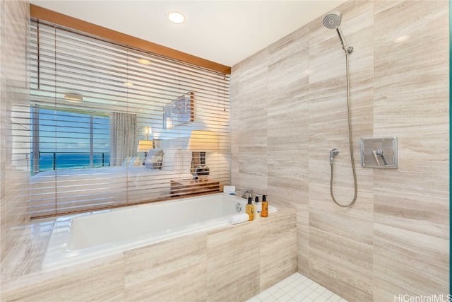 bathroom featuring tile walls and shower with separate bathtub