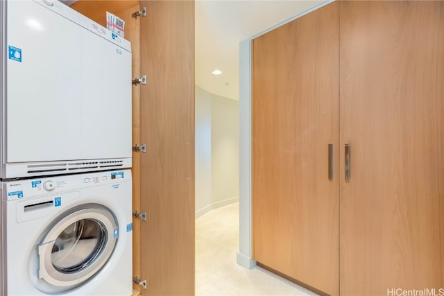 clothes washing area with stacked washer / dryer