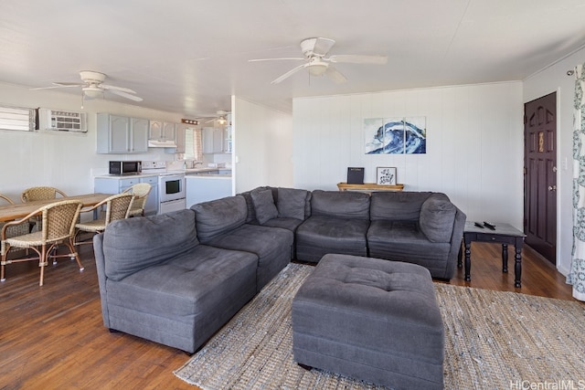 living room with wooden walls, dark wood-type flooring, and ceiling fan