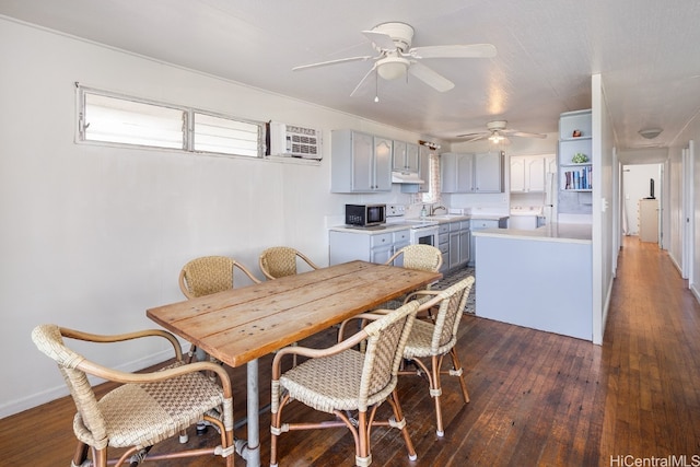 dining area featuring a wall mounted AC, sink, ceiling fan, and dark hardwood / wood-style flooring