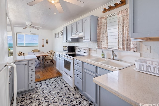 kitchen featuring light hardwood / wood-style flooring, gray cabinetry, sink, electric range, and ceiling fan