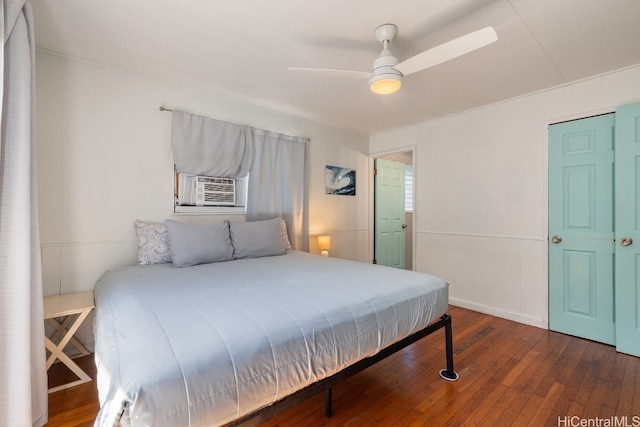 bedroom featuring cooling unit, dark hardwood / wood-style floors, and ceiling fan