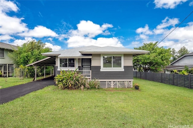 view of front of property with a front lawn, fence, aphalt driveway, metal roof, and a carport