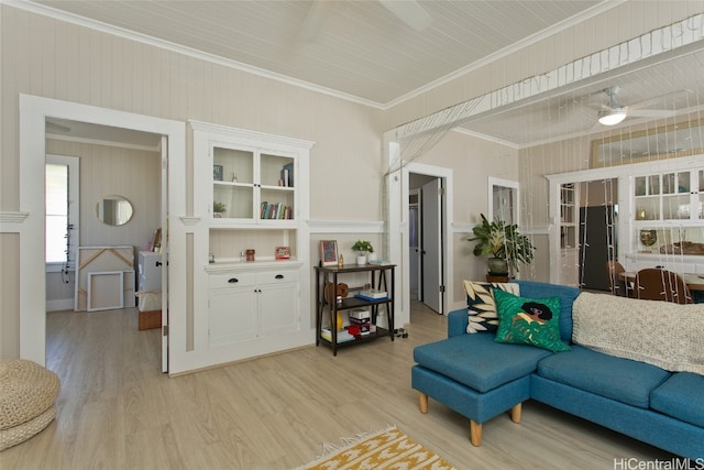 living room with ornamental molding, light wood-type flooring, and ceiling fan