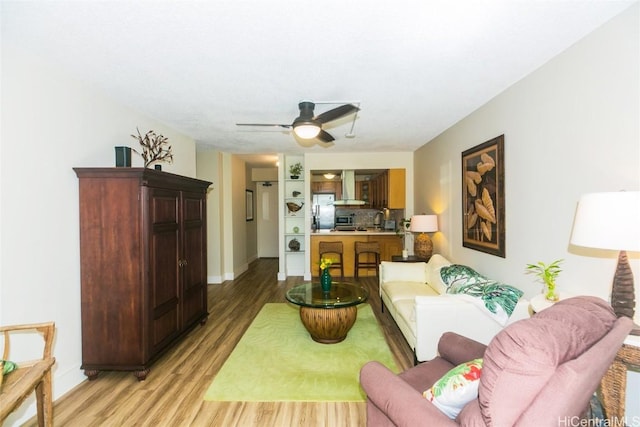 living room with ceiling fan and light wood-type flooring