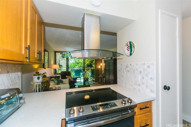 kitchen with electric stove, backsplash, and island range hood