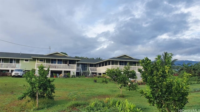 rear view of property featuring a lawn