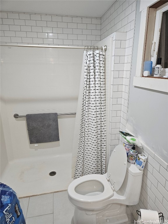 bathroom featuring tile walls, tile patterned floors, toilet, and walk in shower