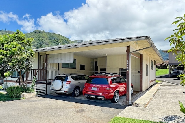 view of parking / parking lot featuring a mountain view and a carport