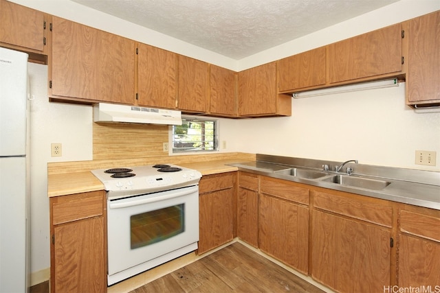 kitchen with sink, a textured ceiling, white appliances, and dark hardwood / wood-style flooring