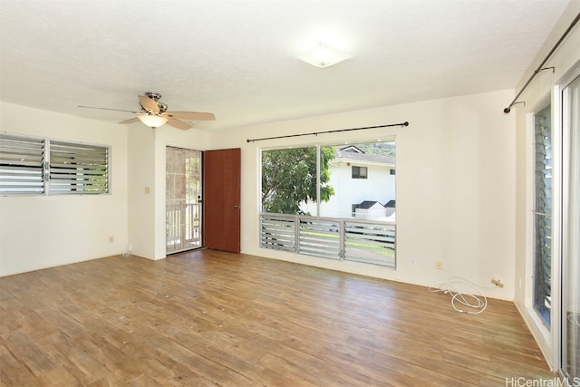 spare room featuring a textured ceiling, wood-type flooring, and ceiling fan