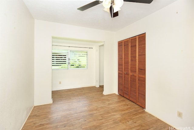 unfurnished bedroom with light hardwood / wood-style flooring, a closet, and ceiling fan