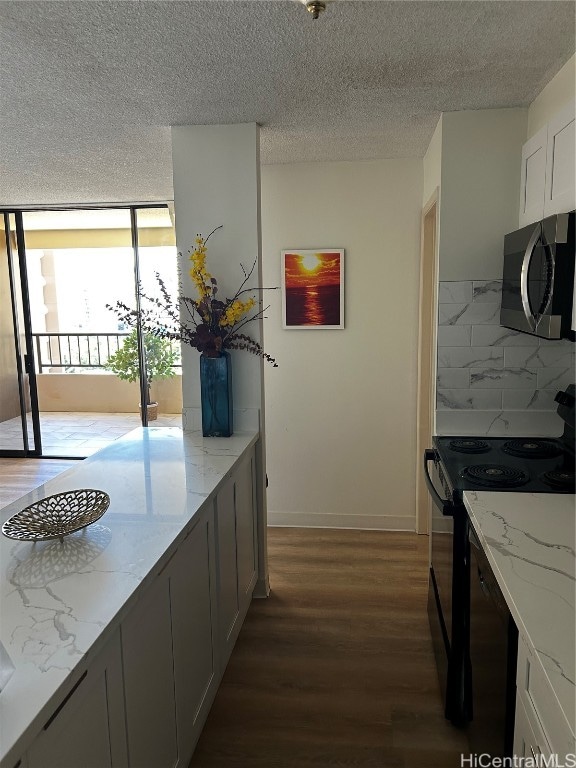 kitchen with decorative backsplash, white cabinets, dark hardwood / wood-style floors, black electric range, and light stone counters