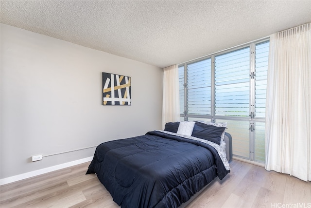 bedroom with a textured ceiling and light wood-type flooring