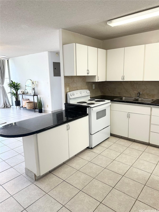 kitchen featuring white electric range oven, backsplash, a peninsula, and a sink