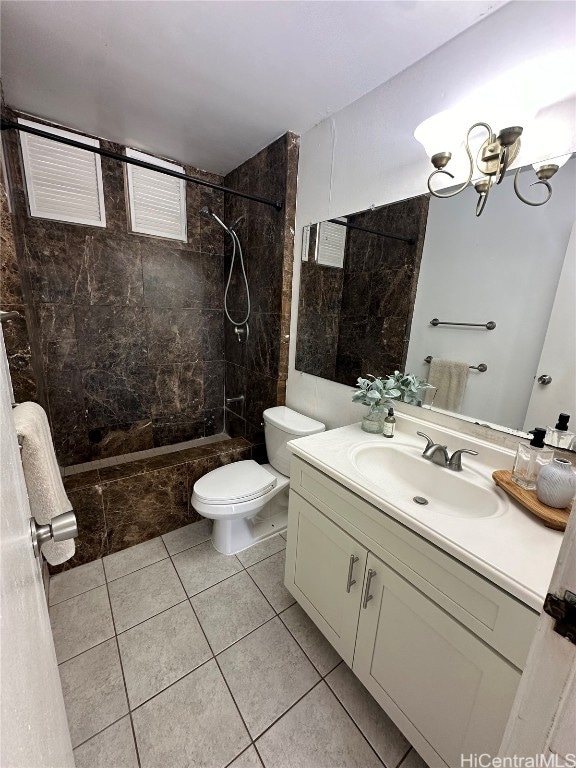 bathroom with vanity, tiled shower, toilet, and tile patterned floors