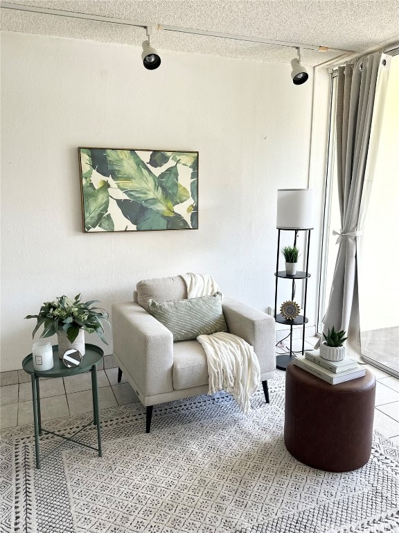 sitting room with a textured ceiling and light tile patterned floors