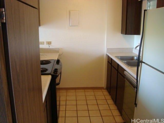 kitchen with sink, light tile patterned floors, and white appliances