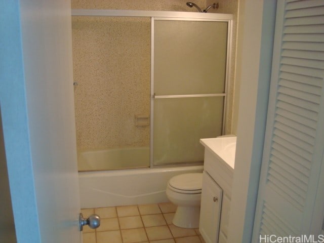 full bathroom featuring vanity, toilet, tile patterned flooring, and bath / shower combo with glass door