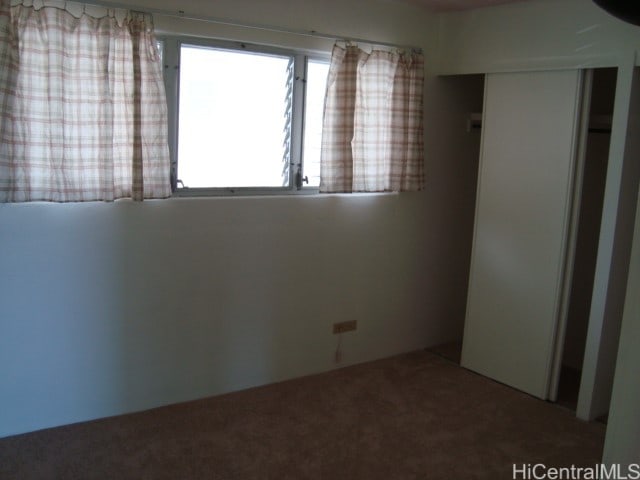 unfurnished bedroom with a closet and carpet flooring