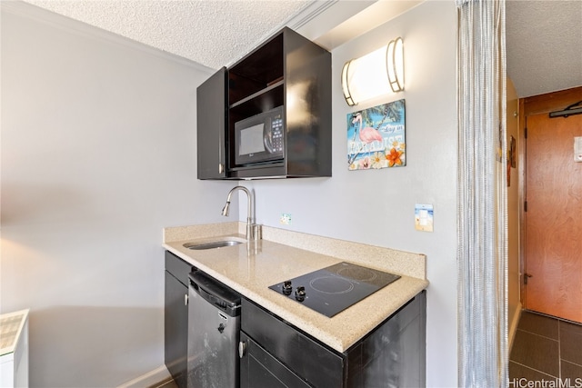 kitchen with a textured ceiling, sink, black appliances, and dark tile patterned floors