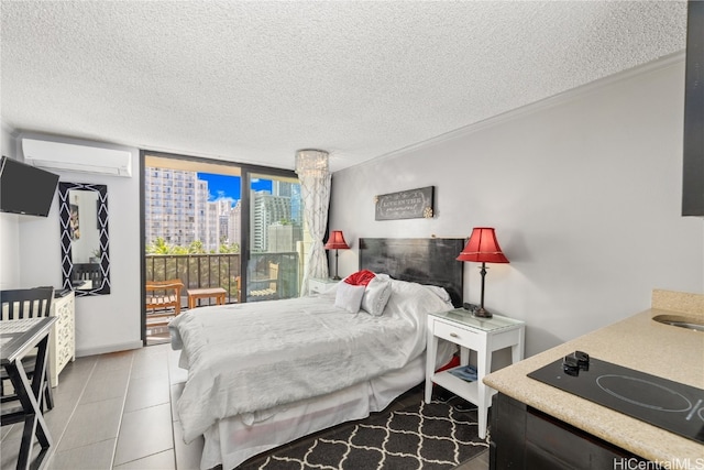 bedroom featuring a textured ceiling, light tile patterned flooring, a wall mounted air conditioner, and expansive windows