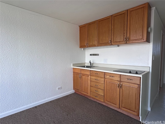 kitchen featuring electric cooktop, sink, and dark carpet