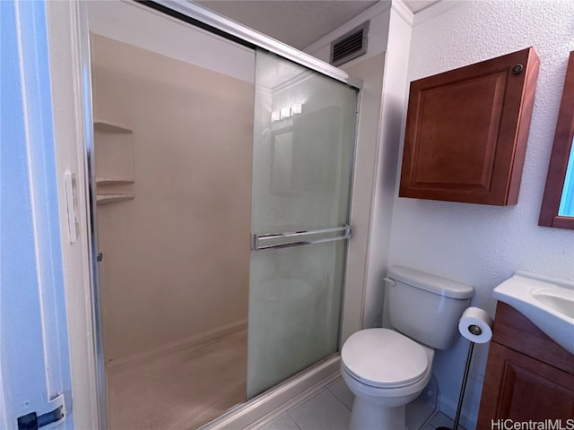 bathroom with vanity, toilet, a shower with shower door, and tile patterned flooring