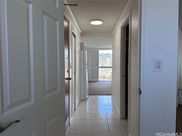 hall featuring a textured ceiling and light tile patterned flooring