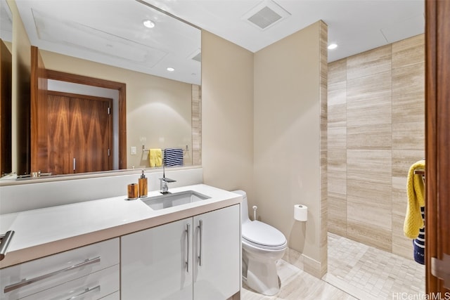 bathroom with vanity, toilet, and a shower