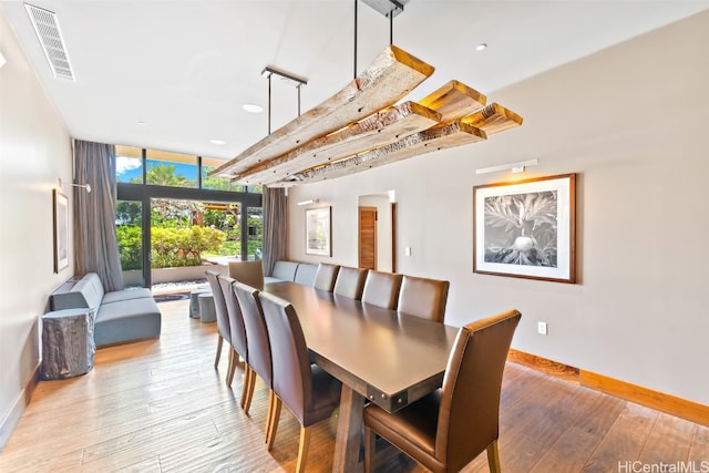 dining room featuring expansive windows and light wood-type flooring