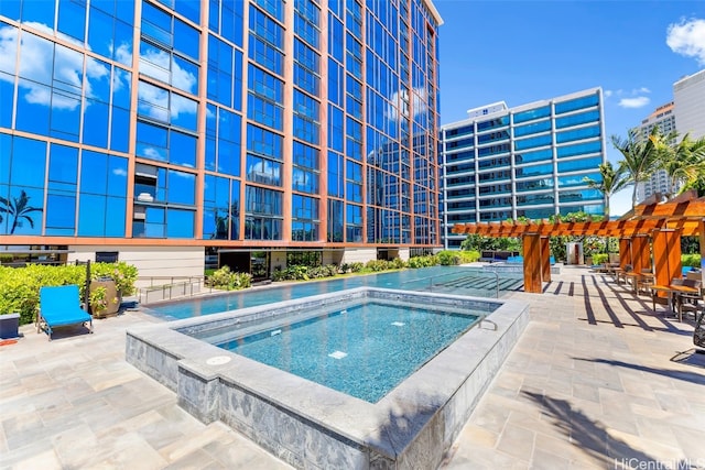 view of pool with an in ground hot tub and a patio