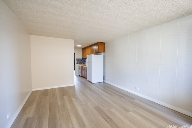 unfurnished living room featuring a textured ceiling and light wood-type flooring