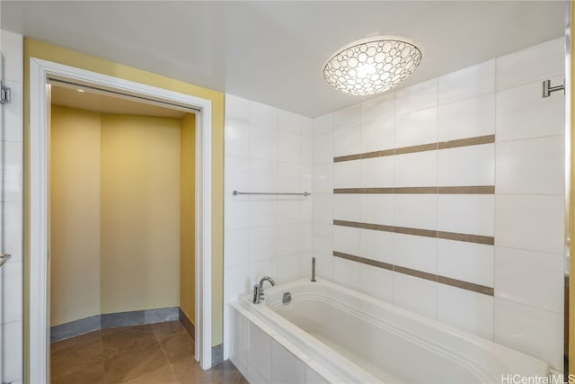 bathroom featuring tiled bath and tile patterned flooring