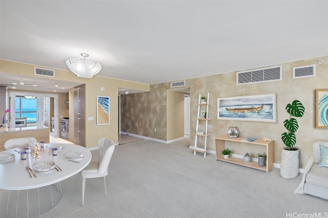 carpeted dining space featuring an inviting chandelier