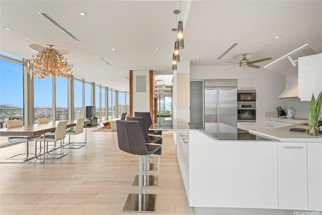 223 Saratoga Rd Unit 3801 Penthouse A, Honolulu, HI 96815 - kitchen with floor to ceiling windows, appliances with stainless steel finishes, ceiling fan, light wood-style floors, and white cabinets