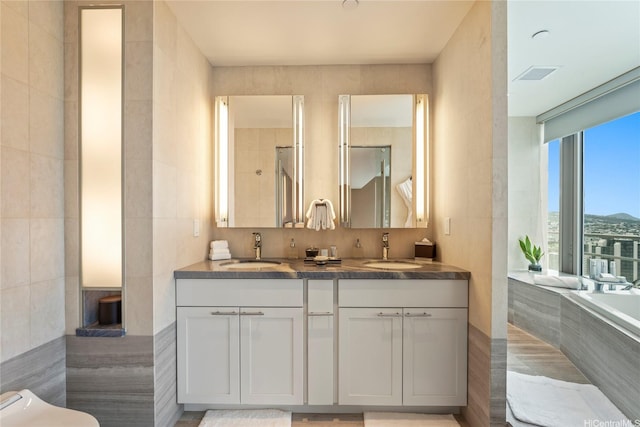 223 Saratoga Rd Unit 3801 Penthouse A, Honolulu, HI 96815 - bathroom featuring double vanity, tile walls, and tiled tub