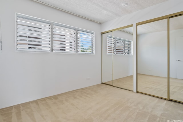 98-707 Iho Pl Unit 2-1404, Aiea, HI 96701 - unfurnished bedroom featuring carpet floors, two closets, and a textured ceiling