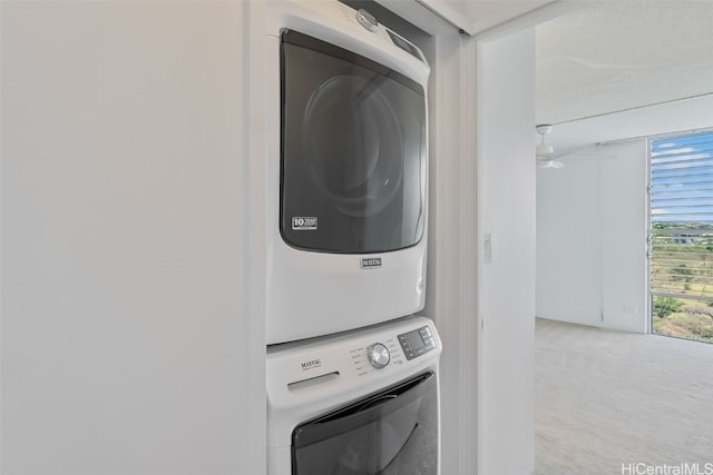 washroom with stacked washing maching and dryer and carpet floors