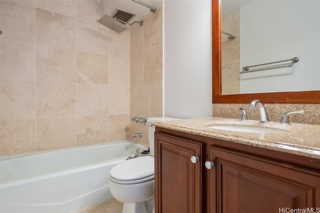 full bathroom with tiled shower / bath, vanity, and toilet