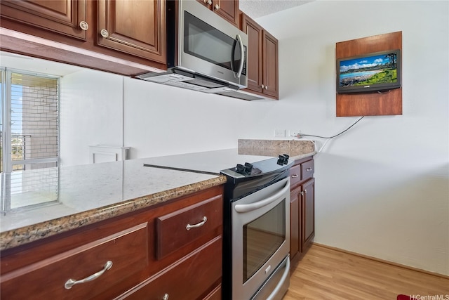 98-707 Iho Pl Unit 2-1404, Aiea, HI 96701 - kitchen featuring appliances with stainless steel finishes, light stone countertops, and light wood-style floors
