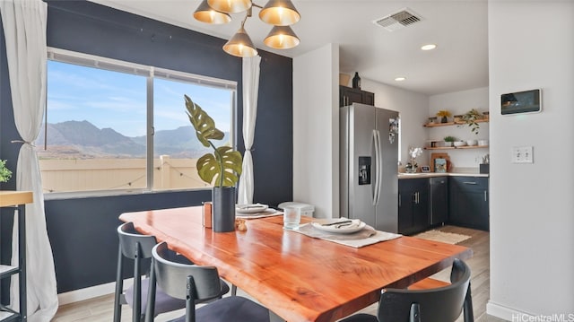 dining area featuring a mountain view and light wood-type flooring