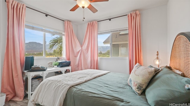 bedroom featuring a mountain view, ceiling fan, and hardwood / wood-style flooring