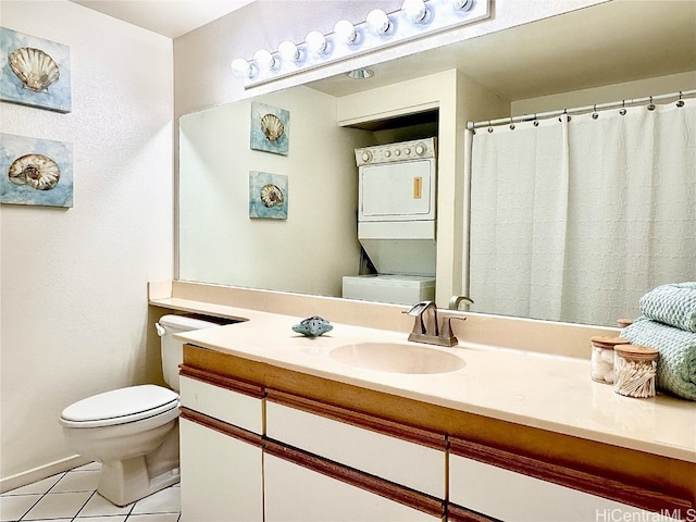 bathroom with toilet, stacked washer and dryer, vanity, and tile patterned flooring